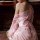 A woman wears a delicate pink japanese kimono-style sleepwear set, featuring floral patterns and a flowing design, perfect fo...