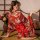 A woman poses elegantly wearing a vibrant red japanese kimono-style sleepwear set, featuring floral patterns and a large bow ...