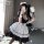 A woman poses in a japanese lolita maid costume set, featuring a black lace bodice and thigh-high stockings, holding a feathe...