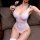 A woman poses wearing a sheer bodysuit, highlighting its elegant design and form-fitting style. the garment features a low-cu...