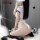 Woman wearing white japanese sailor uniform bodysuit with adjustable straps, posing on fluffy rug with black-and-white balloo...