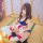 A woman sits on tatami flooring holding a lifebuoy with welcome to jrd printed on it, wearing a blue swimsuit set featuring a...