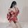 A woman poses in a red japanese-style kimono-inspired lingerie set, featuring a deep v neckline and flowing sleeves, creating...