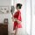 A woman stands by a window wearing a red japanese-style kimono with floral patterns and a bow design, holding a traditional f...