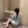 A woman sits on the floor wearing a japanese-style sheer lace bathrobe set, featuring sweet sakura patterns and a bow detail,...