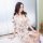 A woman poses elegantly in a sheer floral robe, showcasing its delicate lace detailing and feminine design, perfect for intim...