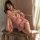 A woman poses elegantly in a sheer pink japanese-style lingerie set, featuring floral patterns and kimono-inspired design, pe...