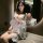 A woman poses elegantly in a sheer kimono-inspired bodysuit, featuring delicate lace detailing and a waist cinching design. t...