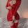 Woman wearing shiny red pvc leather bodycon dress with front zipper, long sleeves, and matching thigh-high boots.