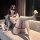 Woman wearing jinxiao jk sailor suit lingerie, a sheer mesh bodysuit with playful elegance, posing on a couch.