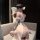 Woman in jinxiao lingerie set, elegant chinese-inspired silk babydoll and robe, holding a fan, seated on a couch.