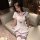 A petite woman wears a white sailor-style jk uniform set, featuring blue accents and knee-high socks, perfect for a schoolgir...