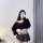A woman poses with a phone featuring a cute face design, wearing a black low-neck sweater and a plaid mini skirt. the outfit ...
