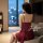 A woman sits on a couch wearing a sheer lace sleep dress by juhuo, featuring a halter neck and cut-out detail, ideal for nigh...