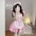 A woman wearing a cute pink maid dress with ruffles and bows, perfect for cosplay or anime-themed outfits.