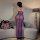 A woman stands facing away from the camera, wearing a purple kouni sensual lace sheer bodycon dress. the dress features a she...