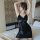 A woman poses elegantly in a black lace babydoll sleep dress, featuring sheer romantic design and flirty feminine details, pe...