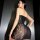 Woman wearing a black lace bodysuit dress with sheer bodycon design and thong back, part of a matching set.