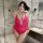 Woman wearing vibrant pink lace bodysuit with open-crotch design in modern bathroom setting.