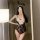 Woman in mirror selfie wearing black lace bunny girl bodysuit with white floral chest panel and headband ears, plus size fit.