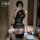 A woman poses in a black lace-embellished cut-out cheongsam dress, featuring elegant embroidery and sheer fabric, paired with...