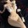 Woman wearing white lace three-piece pearl lingerie set with open-crotch design, feather wand, and rose petals on black fabri...