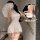 Woman in white lace mesh cheongsam lingerie with sheer vintage design, bare-butt cutout, and tied front detail.