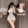 Woman modeling white lace mesh cheongsam lingerie with sheer vintage design, bare-butt cutout, and tied front detail.