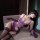 Woman reclining in purple luxury lace satin sexy lingerie set with underwire push-up & sheer thigh-high stockings, sheer mesh...