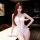 A woman poses confidently wearing a white lace sleepwear set, featuring a sexy design with a deep neckline and cut-out detail...
