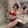 A woman poses in a bathroom wearing a red lace bra and matching panties set, highlighting elegant design details.