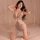 Woman modeling a sparkling rhinestone mesh bodysuit with cut-out details and sheer fabric, styled as seductive lingerie or ni...