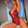 Woman modeling red lace sheer open-crotch bodysuit, sexy sleepwear with floral embroidery and bow detail.
