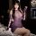 Woman wearing purple lace sheer pearl mock turtleneck bodysuit, seductive see-through mesh lingerie set with cutout sleeves.