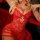 Woman in red lace sheer sleepwear set holding a rose, featuring a seductive camisole and slip nightgown design.