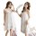 Woman wearing white lace sleep dress with sheer backless design, romantic lingerie set for bedroom.