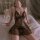 Woman wearing black lace sleepwear set with sheer overlay, featuring a busty illusion design and romantic bedroom style.
