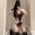 A woman poses in a mirror wearing a black lace bodysuit with sheer details, open-crotch design, and thigh-high stockings, exu...
