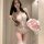 A woman poses in a lace bodysuit with sheer details, featuring an open design and delicate straps. she holds a bouquet of pin...