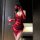 Woman in red lace temptation cross-strap nightgown holding wine glass, silk-like backless boudoir dress with floral hair acce...