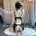 Woman wearing black lace temptation lingerie set with open-crotch bodysuit, kneeling on white rug.
