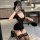 Woman in black lace temptation lingerie set, sheer bodysuit with lace trim and thigh-highs, posing indoors.