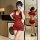 Woman in red lace bodysuit with sheer panels and mini dress silhouette, posing in front of mirror holding rose and phone.