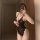 A woman poses in a mirror wearing a black lace bodysuit, featuring an open-crotch design and sheer mesh details. the set incl...