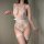 Woman wearing white lace tie-up halter bodysuit with sheer open-crotch design and matching thigh-high stockings.