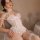 Woman wearing white lace lingerie set with sheer stockings and open-crotch design, featuring push-up bust and delicate floral...