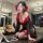 A woman wearing a red and black japanese-inspired kimono sleepwear, featuring an off-shoulder design and lace mask, poses pla...