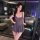 A woman poses elegantly in a stylish, form-fitting gray dress with a plunging neckline and flared skirt. the outfit features ...