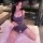 A woman poses on a bed wearing a purple lemon story sexy sheer sleep dress, featuring cute lace-trimmed stockings and a backl...