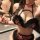 Woman wearing luxury leopard print maid costume set with black fur trim, choker, and braided hair.
